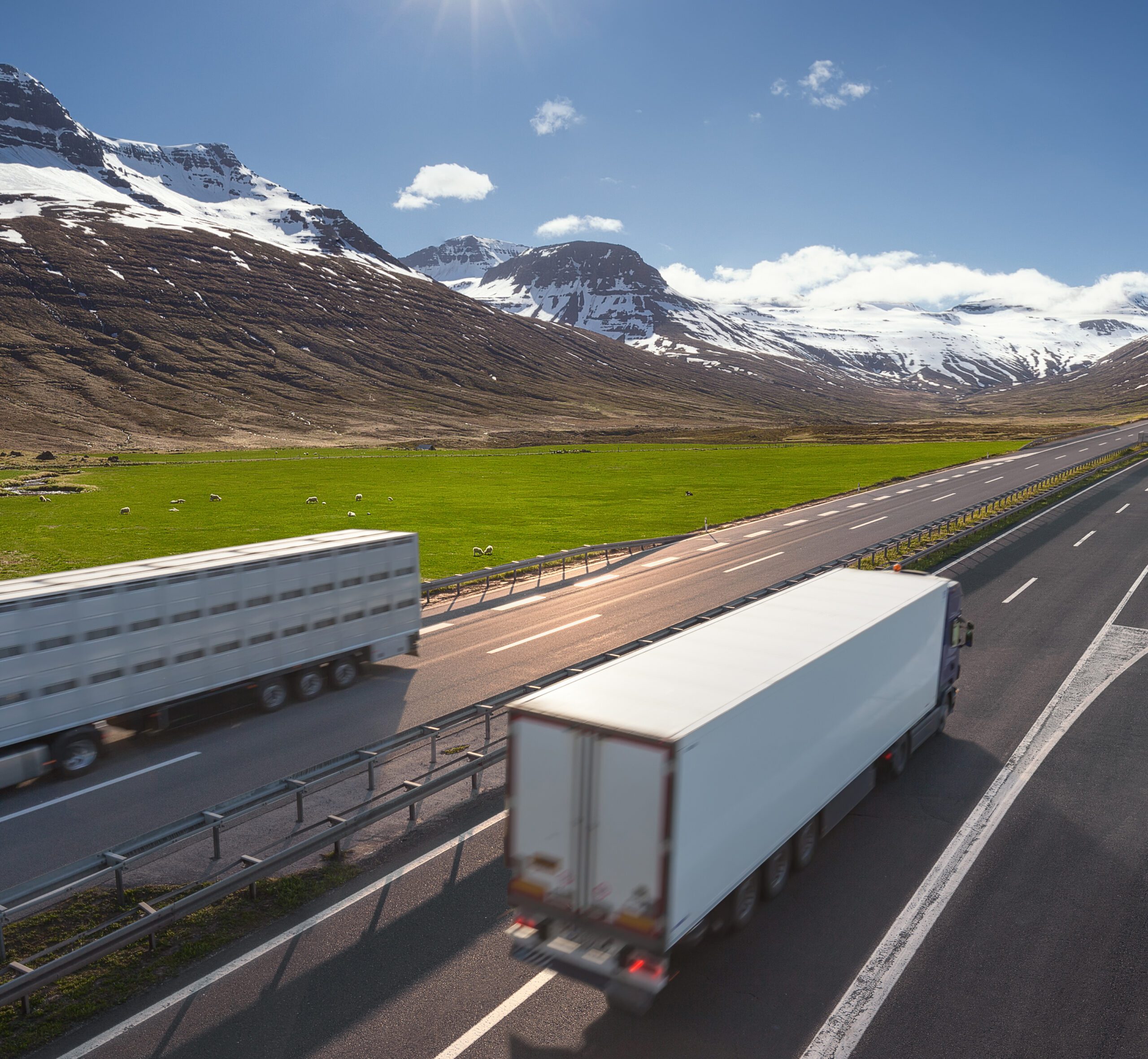 18-wheeler trucks driving past each other on highway surrounded by Canadian mountains