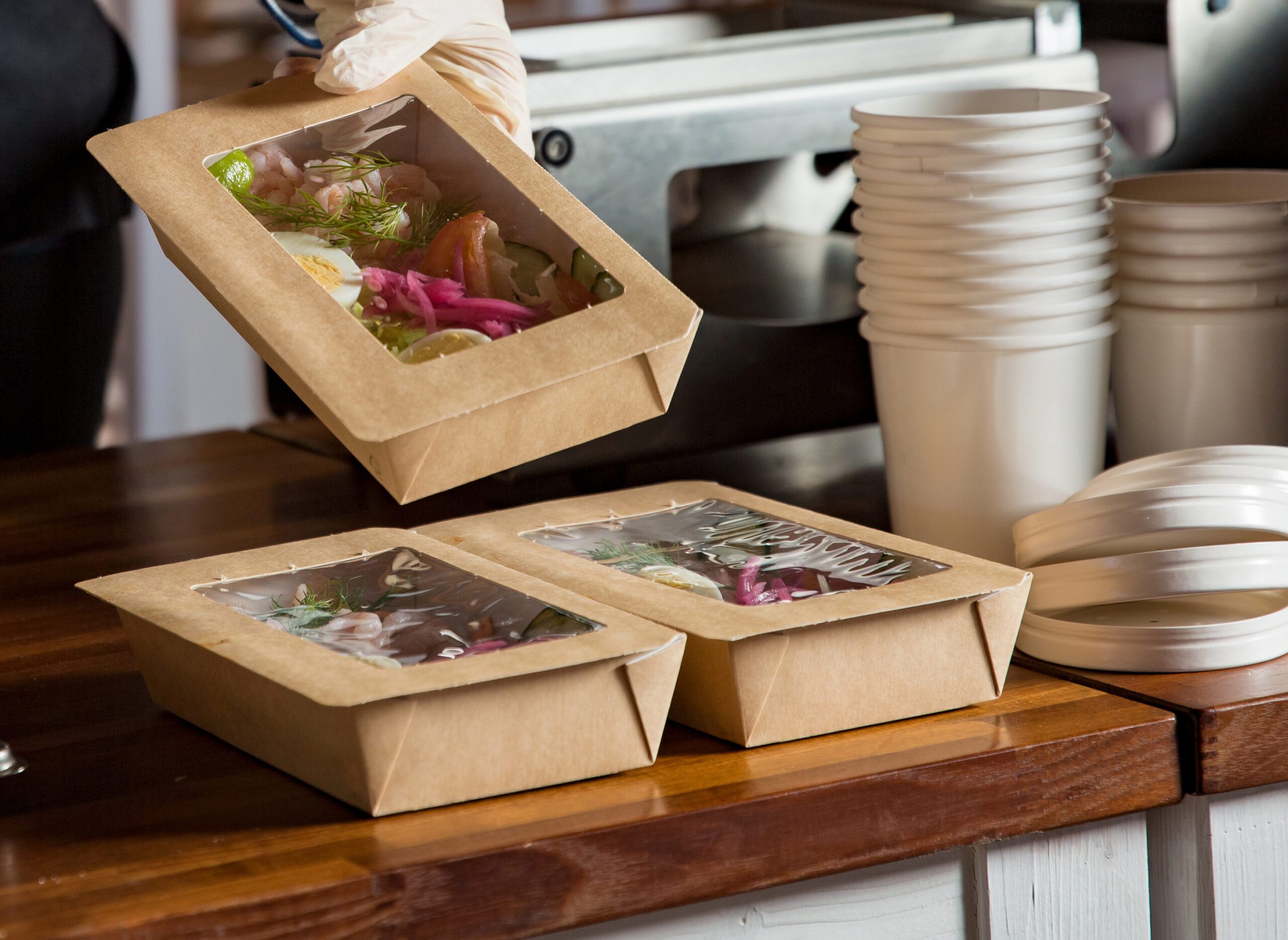 Restaurant worker prepares to-go orders for customer pick-up.